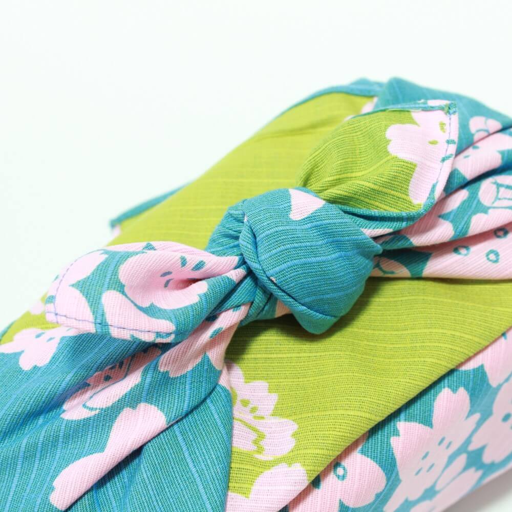close up tied knot baby blue green furoshiki sakura patterns