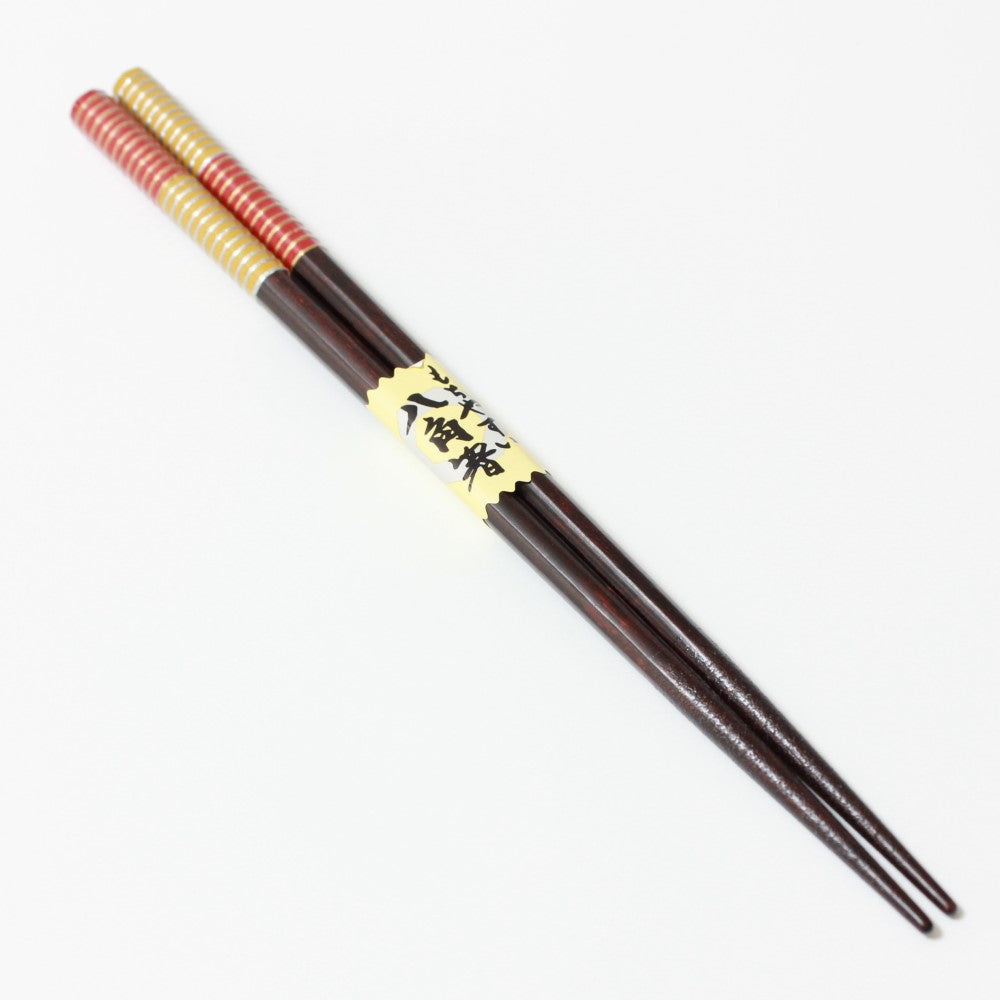 diagonally positioned musou red chopsticks full length