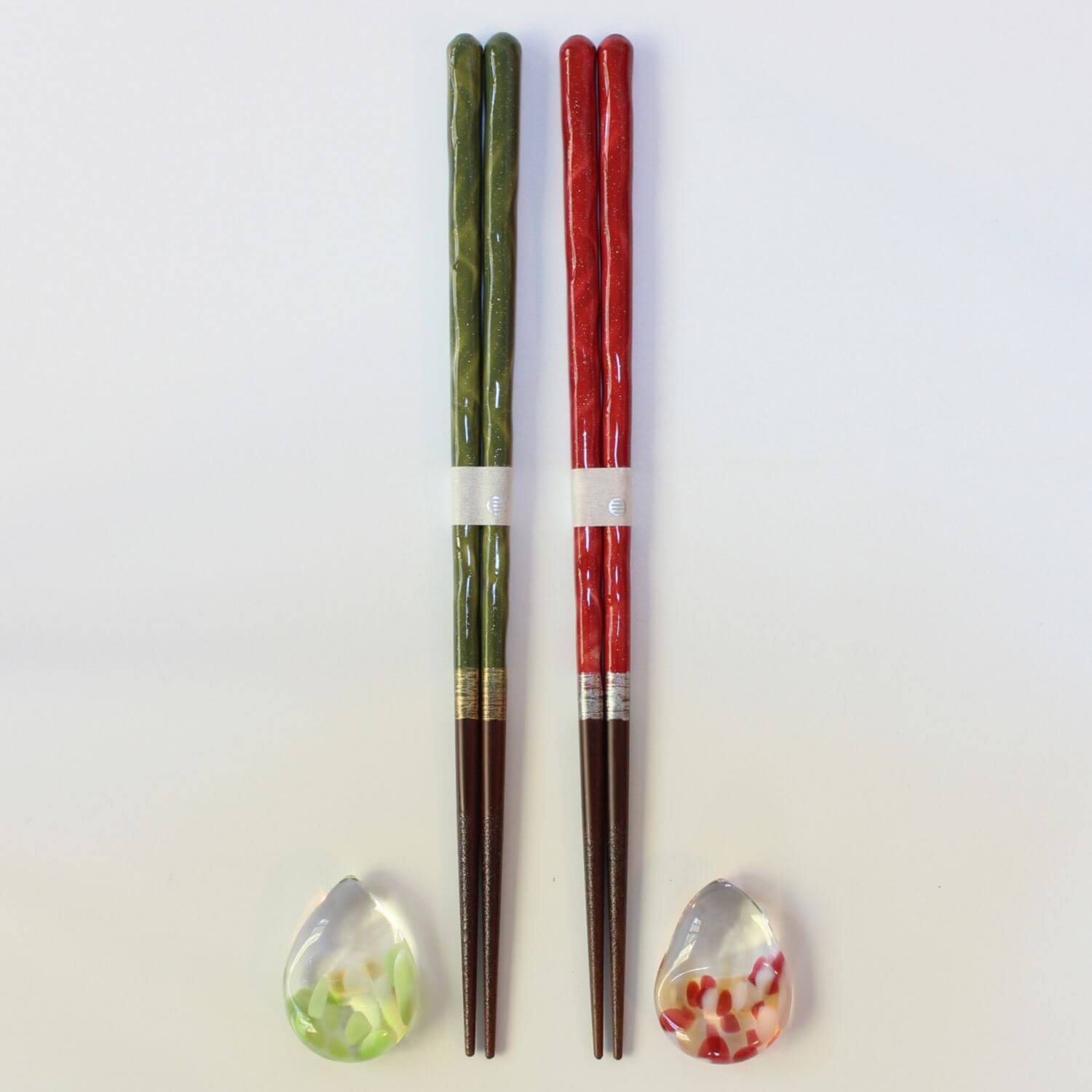 green and red nagisa chopsticks with rests on the side