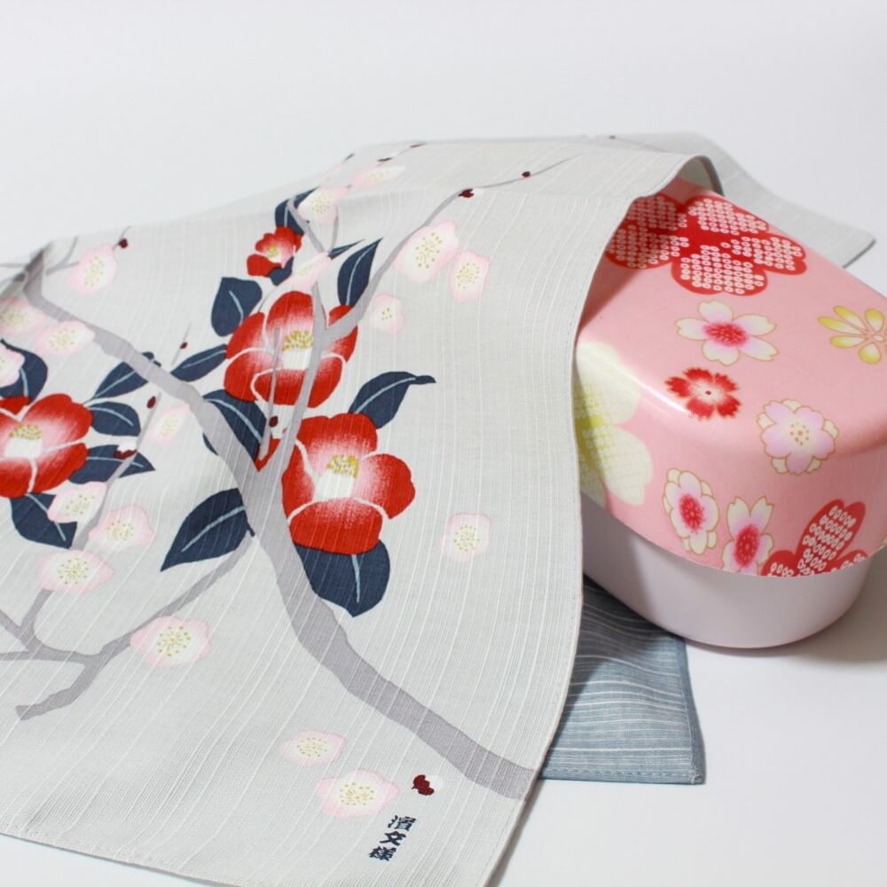 plum and camellia furoshiki covering a pink bento box