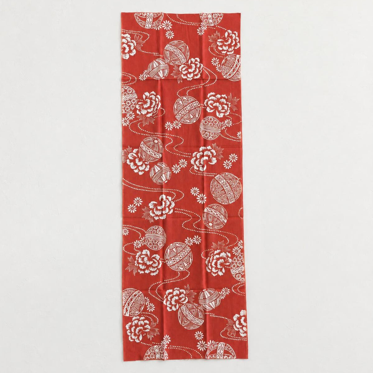red tenugui featuring temari balls and flower patterns from todaya shoten