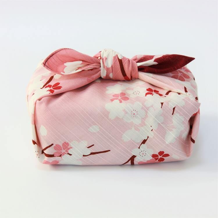 side photo of a bento box wrapped in sakura scape japanese wrapping cloth
