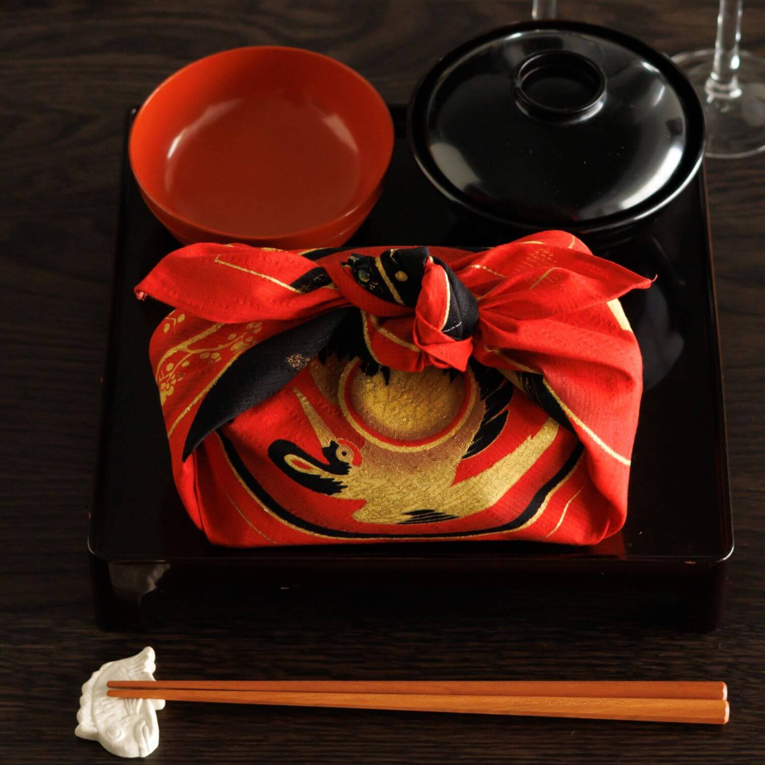 bento box wrapped in red furoshiki with japaense lacquerware design