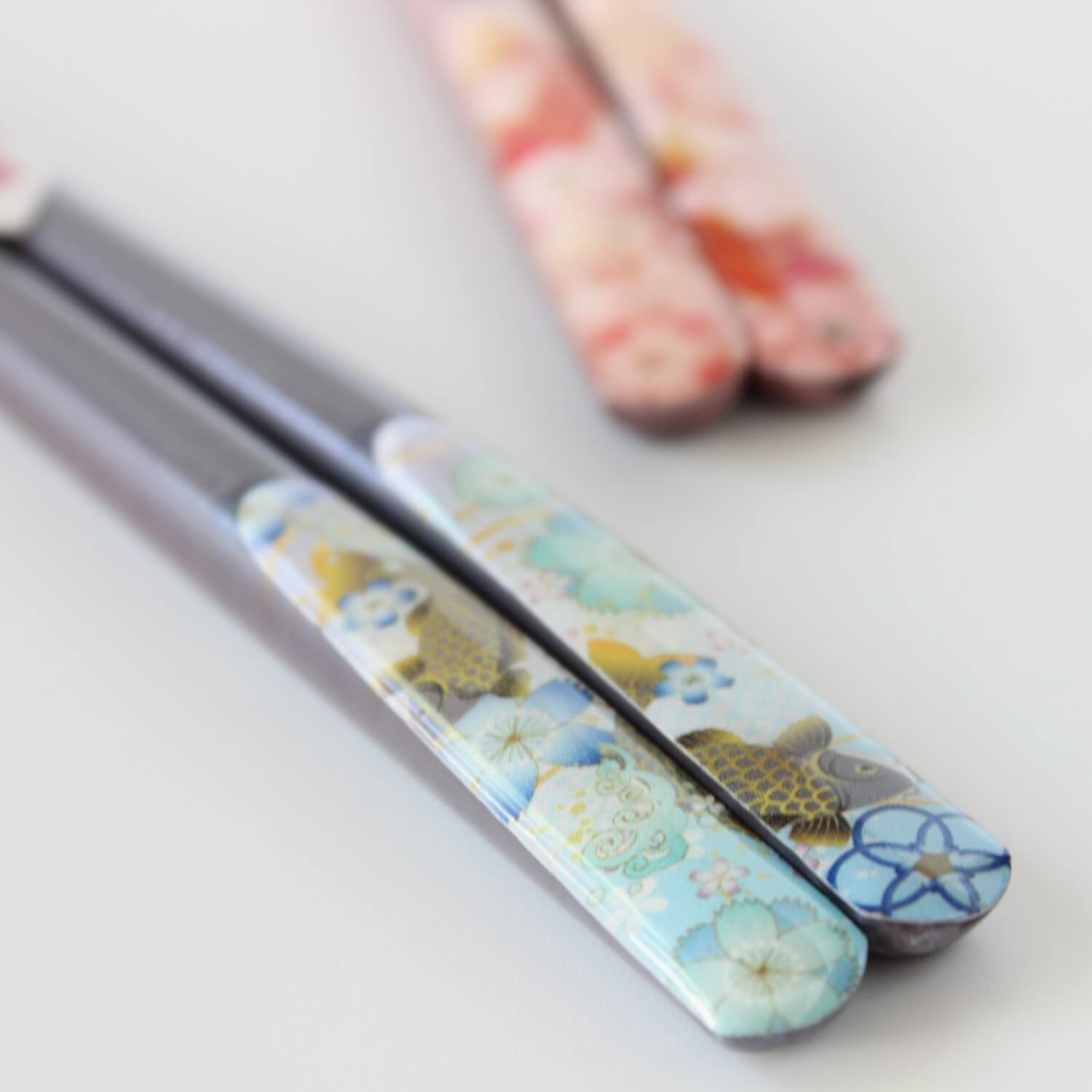 stylish shot in the foreground of a chopsticks handle showing carp fish