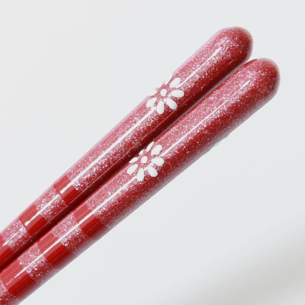 ultra close up showing flower pattern on the surface kainichirin red chopsticks