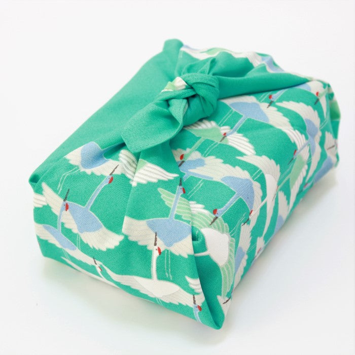 side angle picture of turquoise coloured furoshiki with sedge of cranes