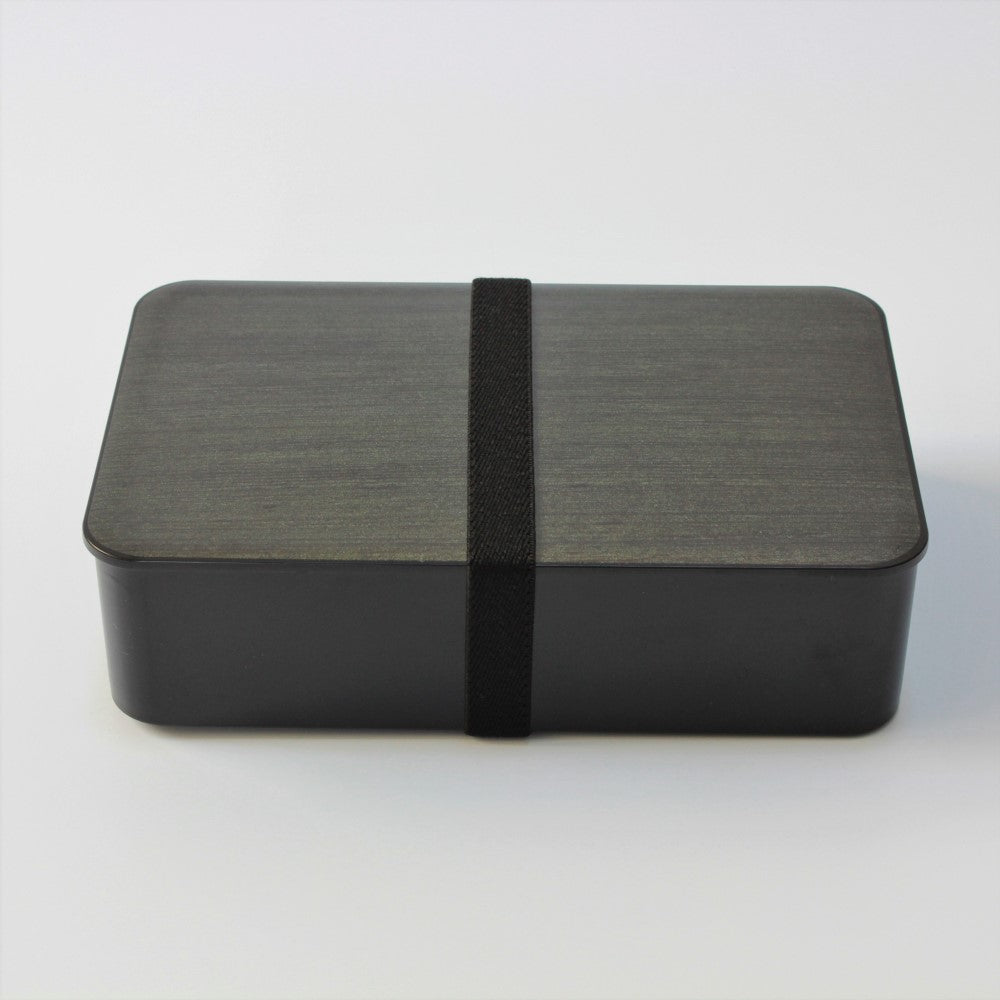 Side view of walnut woodgrain bento lunch box with lunch band securing the lid