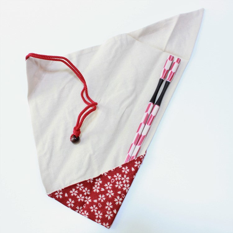 a pair of chopsticks tucked into the sakura chirashi red chopsticks case