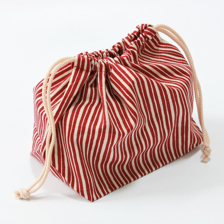 side angle view of tokusa stripes red bento bag storing a bento box