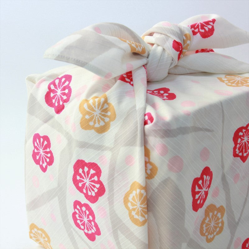 angled side view showing a wrapped bento lunch picnic box with a yumeji takehisa japanese apricot furoshiki