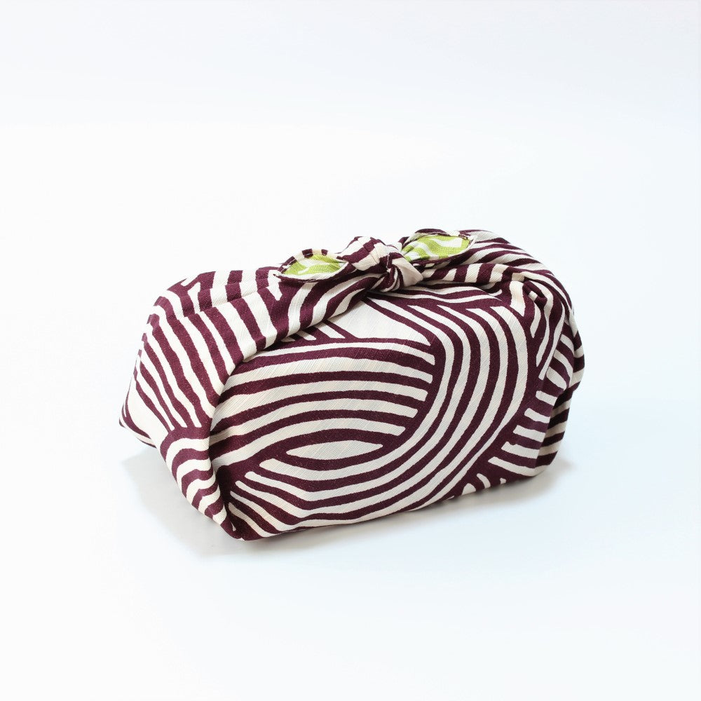 Zoomed out view of the wrapped bento box with this Isa Monyo Knot Purple Green Furoshiki