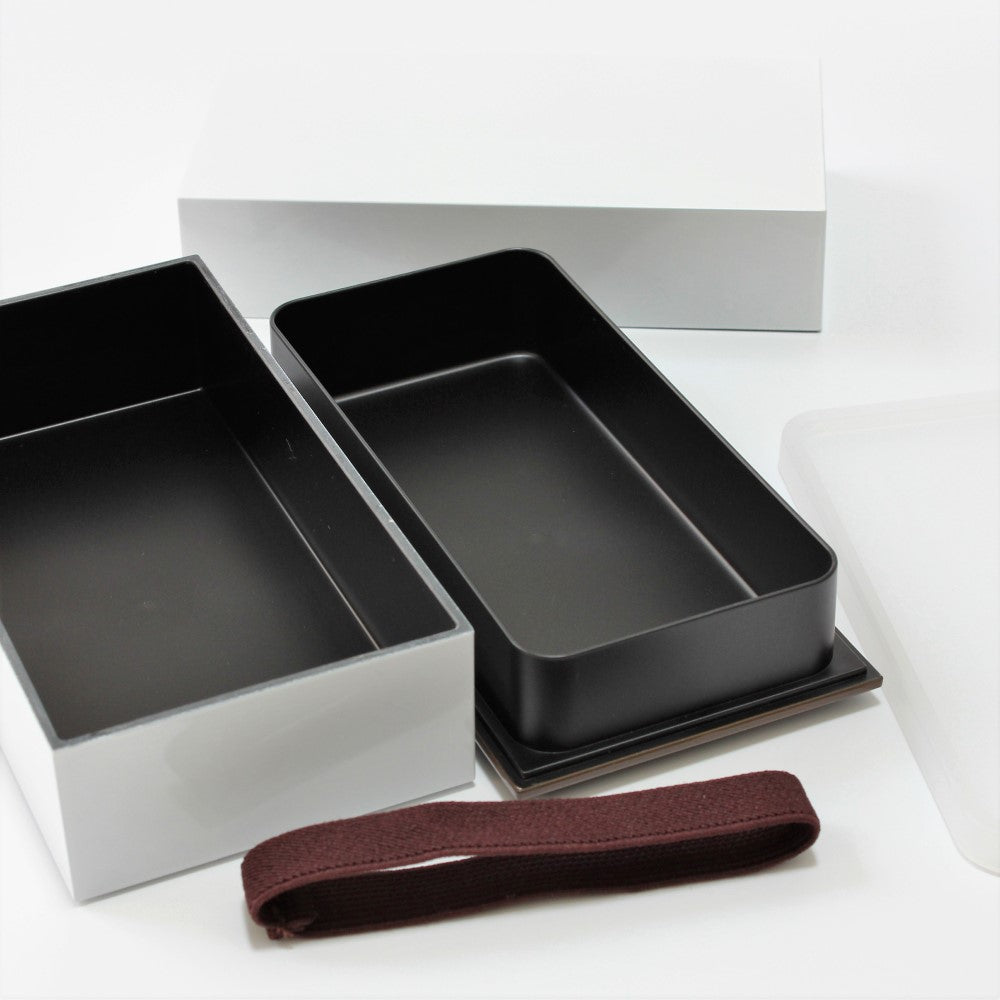 The top layer has a inner lid which can be detached. Image shows a lunch band and the bento box taken apart to its contents