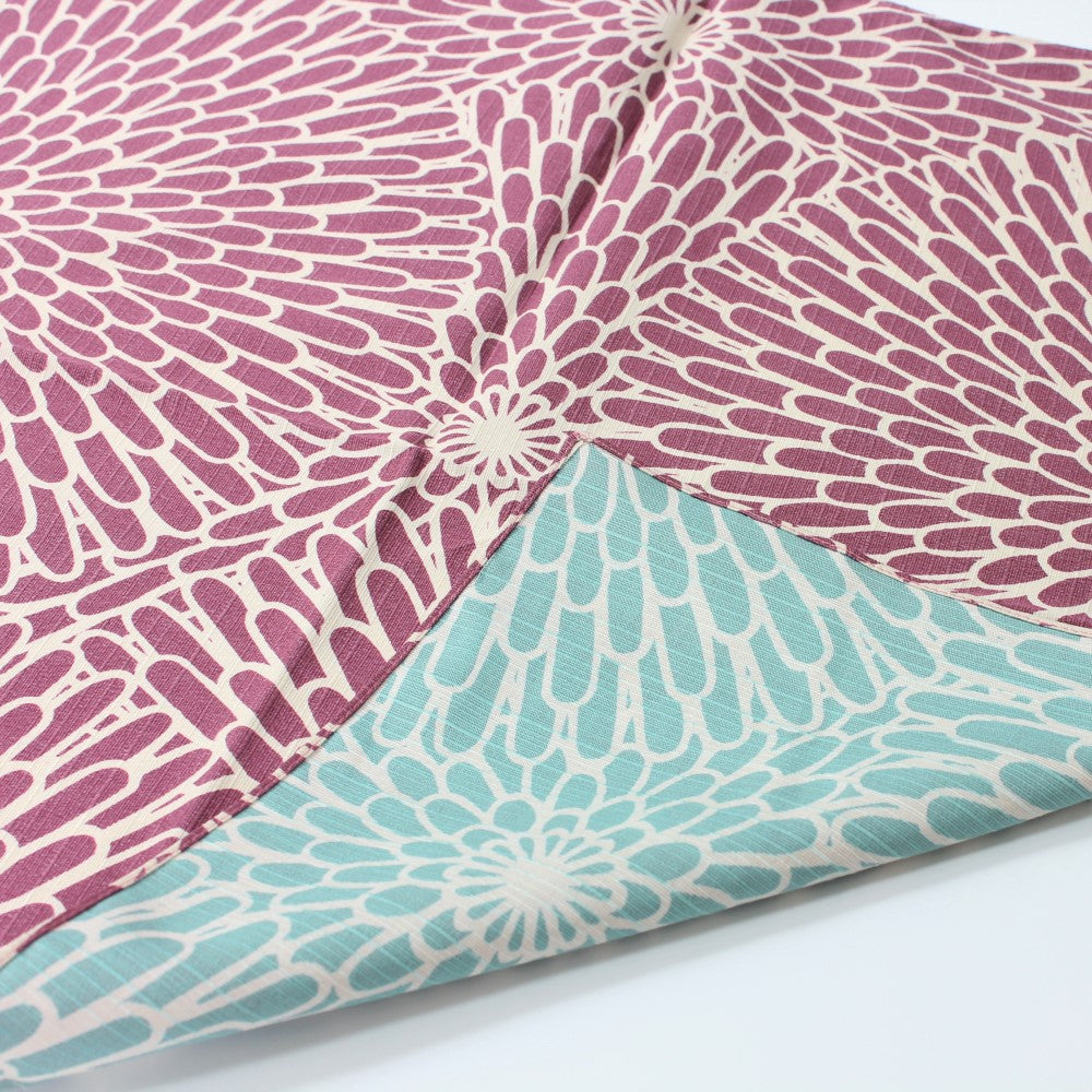 Chrysanthemum flowers resembling fireworks, on a purple and sage blue background in this furoshiki. 