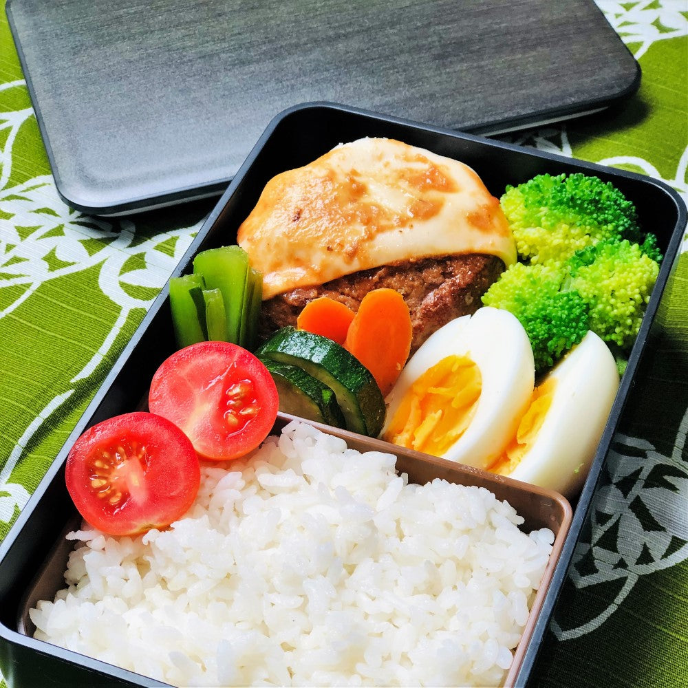 Japanese hamburg steak with cheese, veges, and boiled egg inside the walnut woodgrain bento box