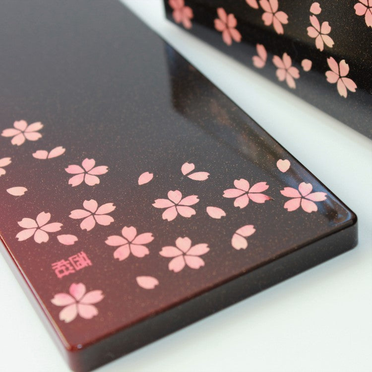 close up shot showing the gold lacquered surface and sakura flowers