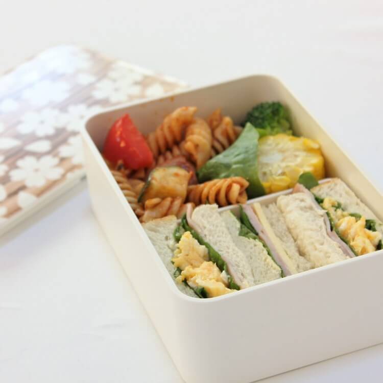 Japanese bento box with sandwich and pasta inside