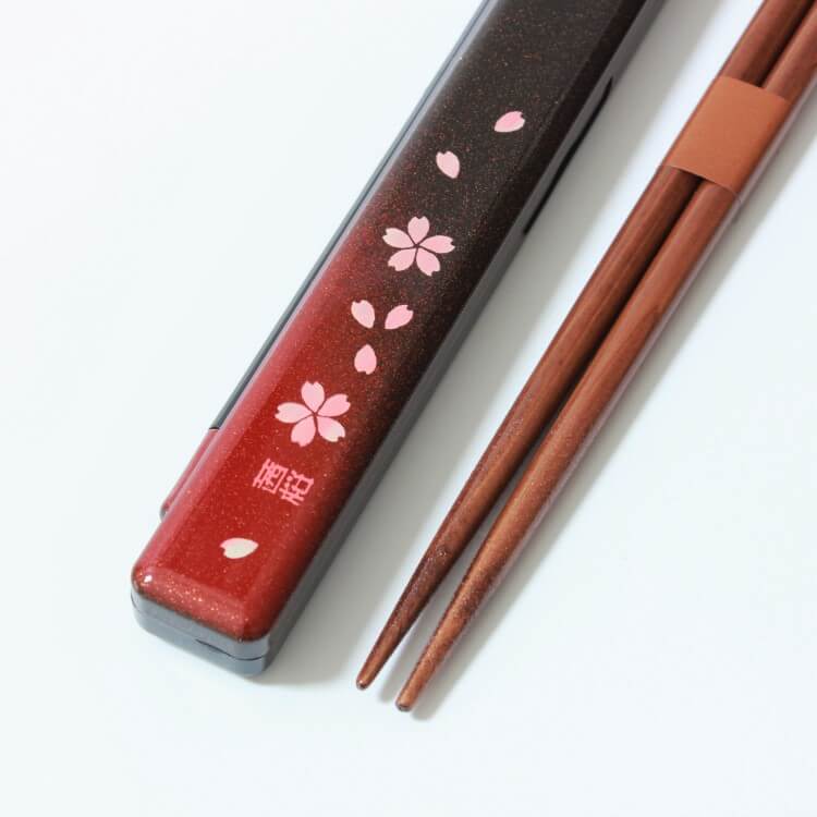 close up shot showing the sakura flowers on the chopsticks case and tips of chopsticks