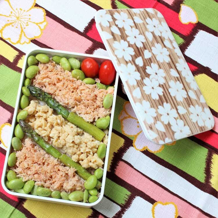 Sakura Mokume 1 tier bento box with asparagus and minced egg food. Bento box is on a colourful furoshiki.