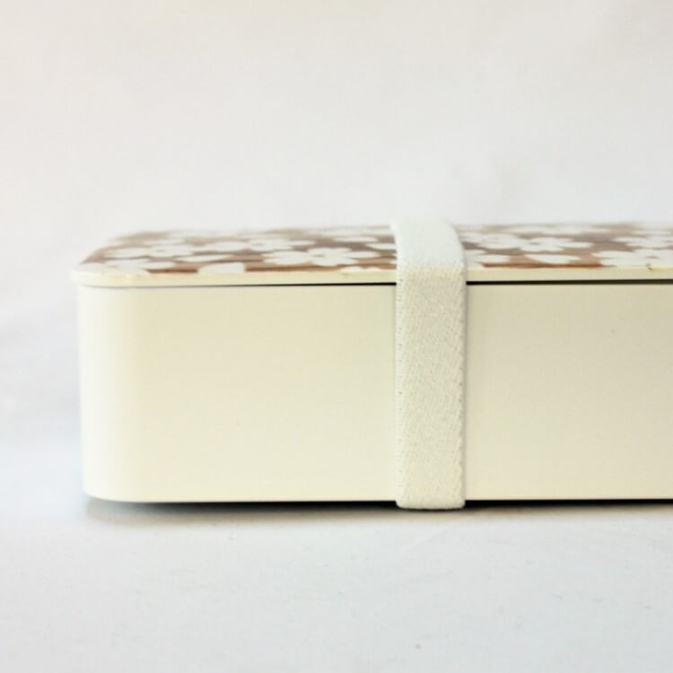 Side view of sakura mokume white bento box with lunch band securing the lid